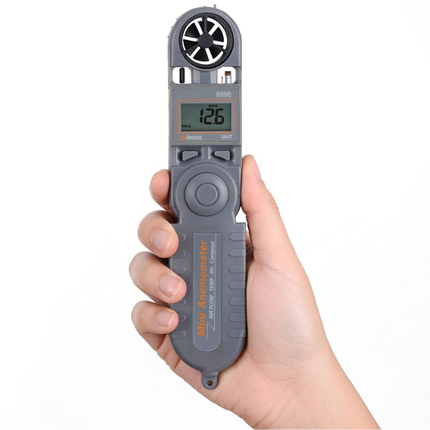 A hand holding the AZ 8996, utilizing the built-in compass for navigation and wind check.